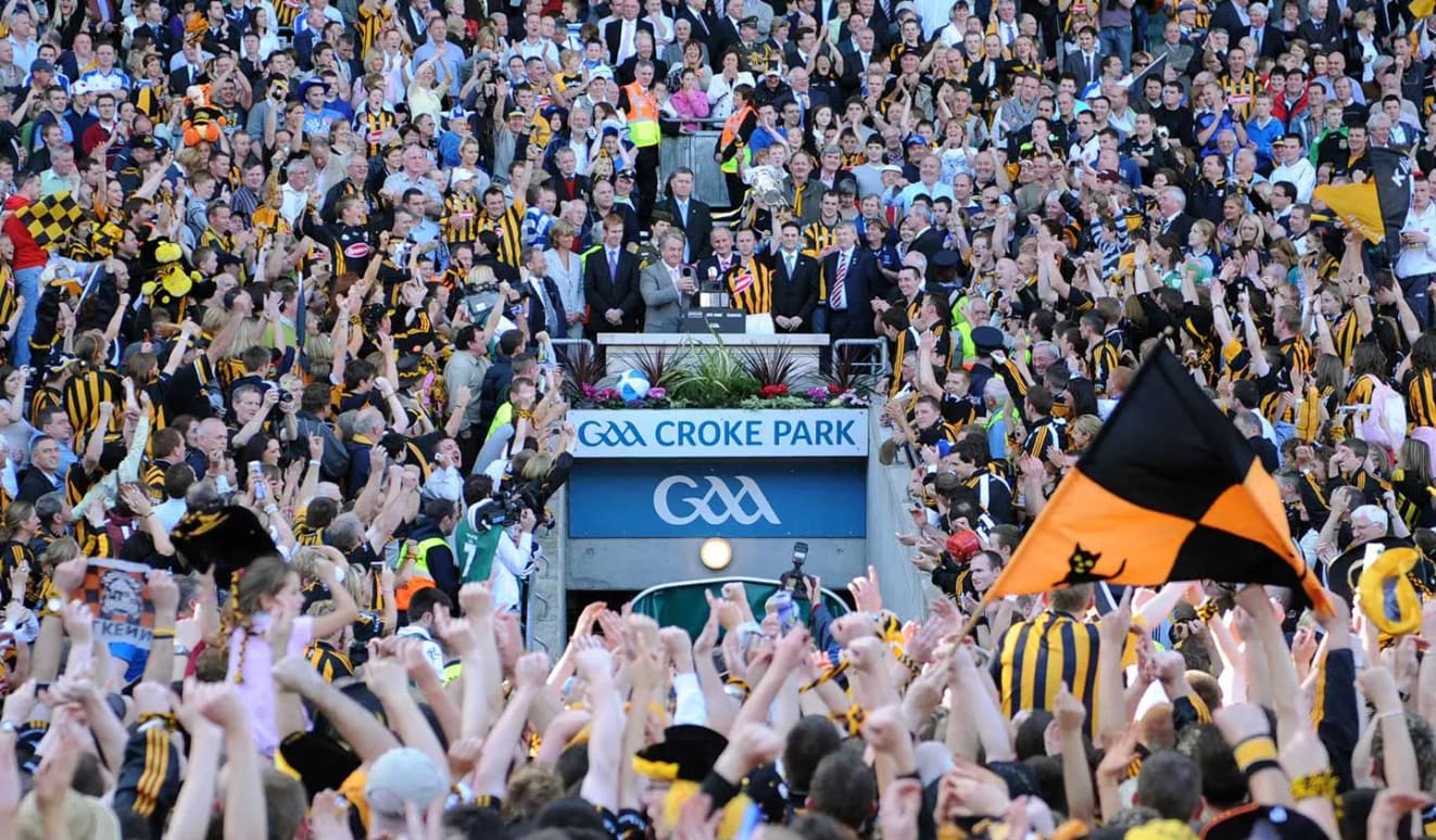 Former GAA President, Nickey Brennan, presents Kilkenny captain James 'Cha' Fitzpatrick with the Liam MacCarthy Cup after the 2008 All-Ireland SHC Final with the new GAA logo emblazoned above the Hogan Stand tunnel.